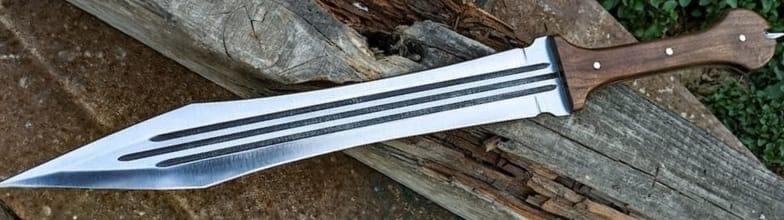 Gladius short sword with a leaf shaped double edged blade, three fullers and a wooden handle